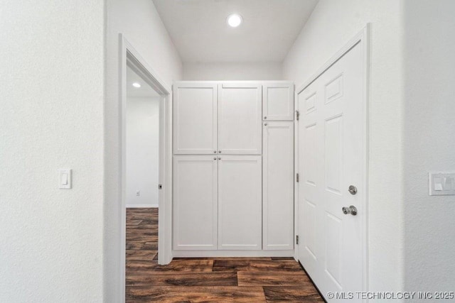 hallway featuring recessed lighting and dark wood-type flooring