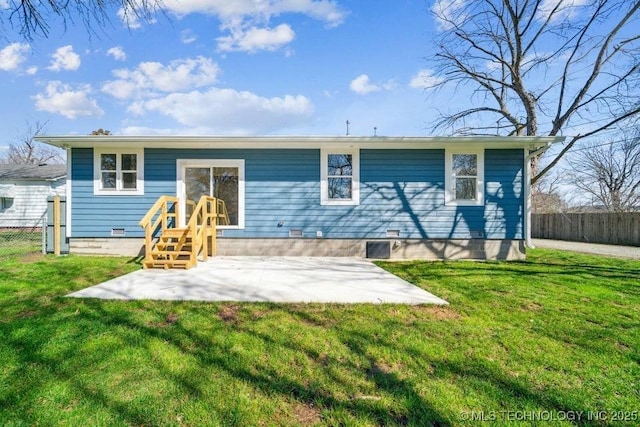 rear view of house with fence, a yard, and crawl space