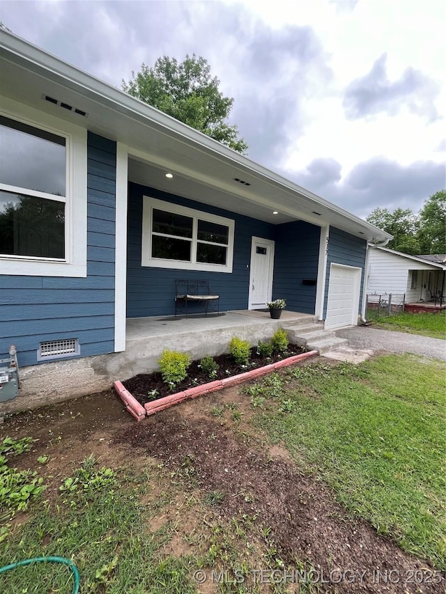 517 W Clyde Ave, Vinita, OK 74301 - view of front facade with covered porch, an attached garage, and asphalt driveway