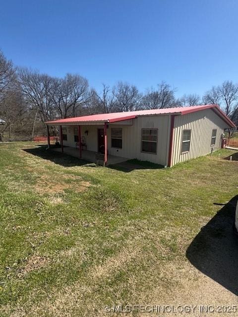 exterior space with metal roof and a front yard