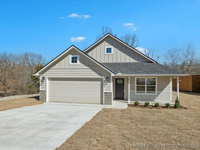 view of front of home featuring covered porch, stone siding, board and batten siding, and concrete driveway