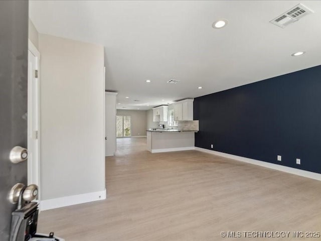 unfurnished living room featuring light wood-style flooring, recessed lighting, visible vents, and baseboards