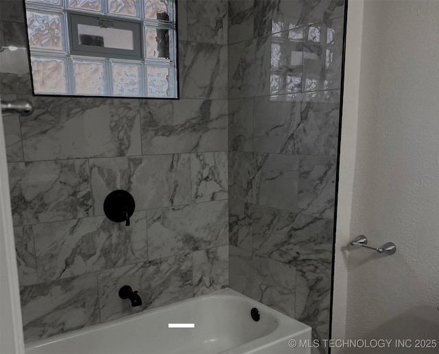 full bathroom with a textured wall and washtub / shower combination