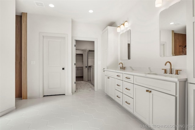 bathroom featuring a sink, visible vents, recessed lighting, and double vanity