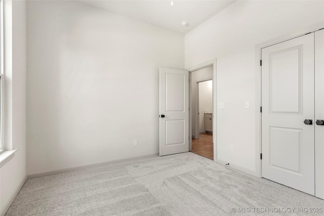 unfurnished bedroom featuring a closet, baseboards, and carpet floors