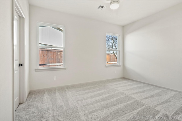 carpeted empty room featuring visible vents, baseboards, and a ceiling fan