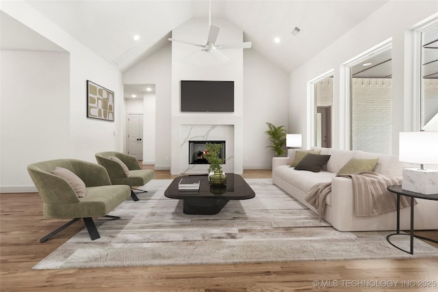 living room featuring visible vents, baseboards, a fireplace, wood finished floors, and a ceiling fan