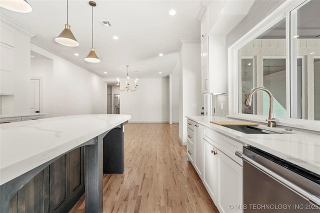 kitchen featuring visible vents, a sink, white cabinets, stainless steel dishwasher, and crown molding