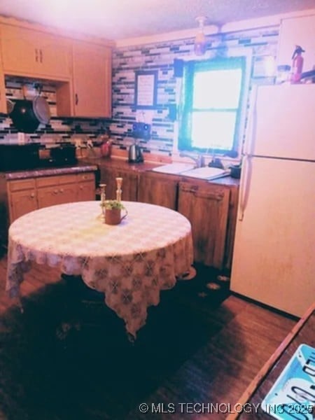 kitchen featuring wood finished floors and freestanding refrigerator