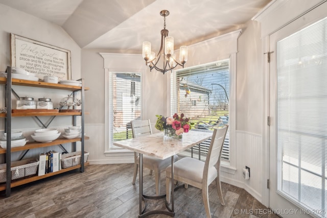 dining room with an inviting chandelier, a wainscoted wall, and wood finished floors
