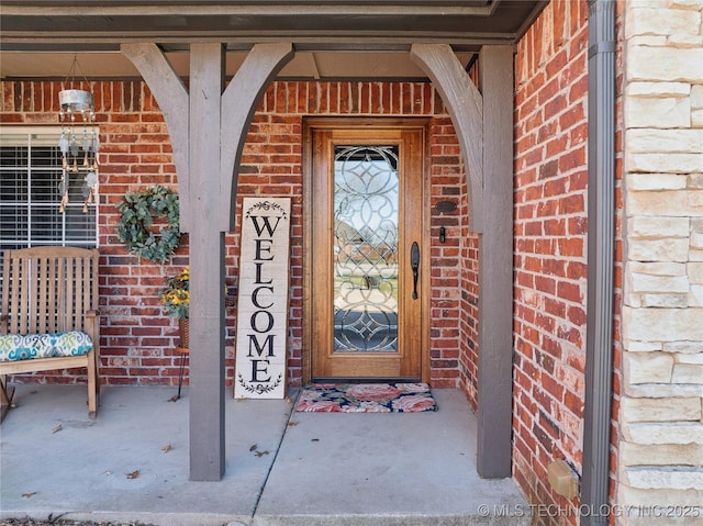 view of exterior entry with brick siding