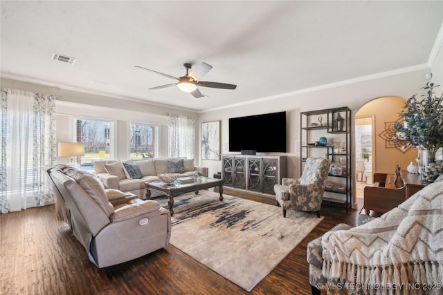 living room featuring visible vents, arched walkways, and dark wood-type flooring