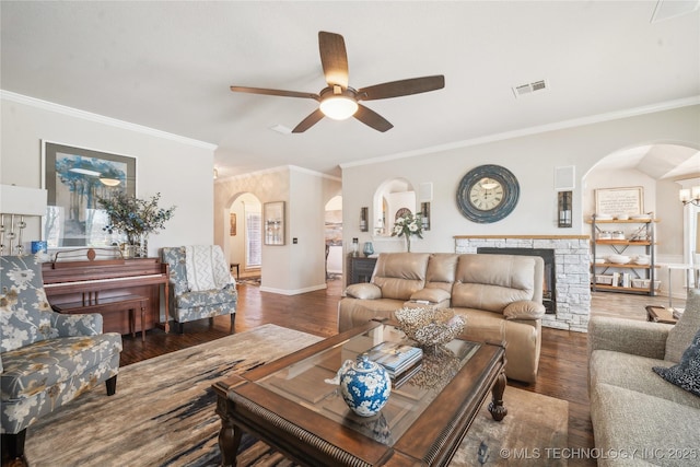 living room with arched walkways, visible vents, a fireplace, and wood finished floors