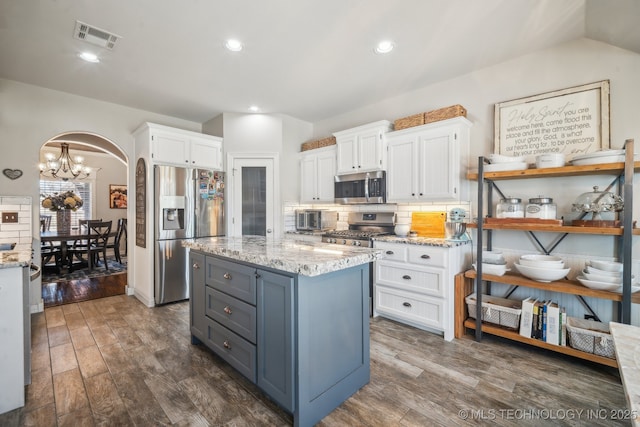 kitchen with white cabinets, stainless steel appliances, visible vents, and dark wood-style floors