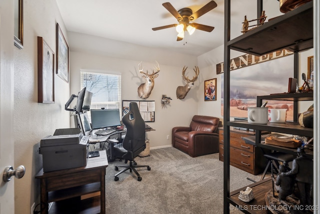 carpeted home office with baseboards and a ceiling fan