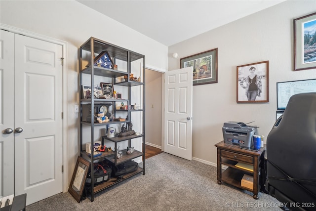 carpeted office space featuring baseboards