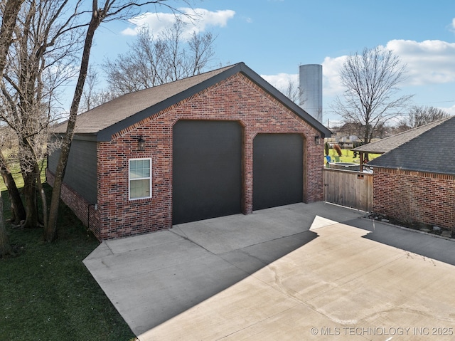 detached garage featuring fence