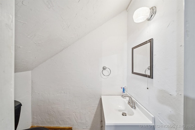 bathroom featuring vaulted ceiling and vanity