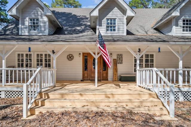 view of front facade featuring covered porch and roof with shingles