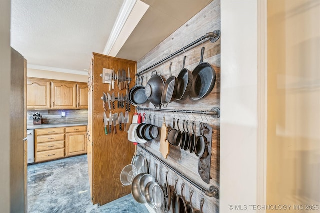 interior space with tasteful backsplash, a textured ceiling, light countertops, and crown molding