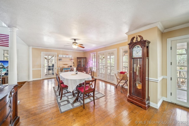 dining space with light wood-style floors, french doors, and a healthy amount of sunlight