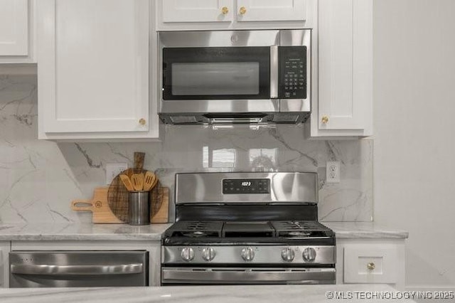 kitchen featuring light stone countertops, white cabinetry, stainless steel appliances, and decorative backsplash