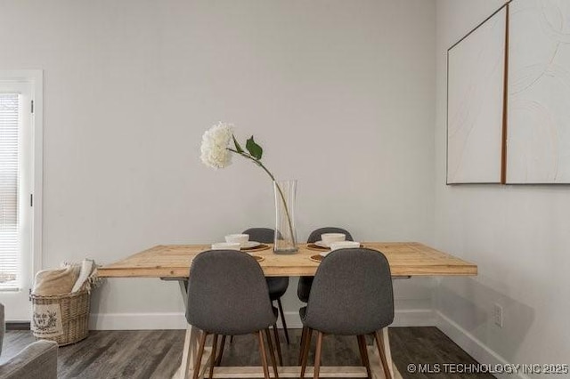 dining space featuring baseboards and wood finished floors