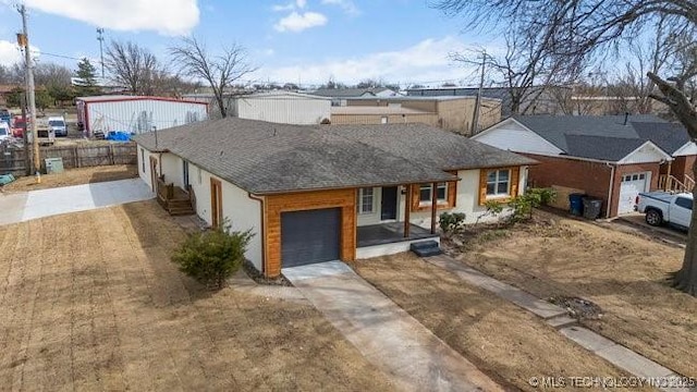 view of front of property featuring driveway, an attached garage, and fence