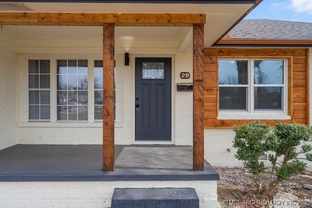 doorway to property featuring roof with shingles