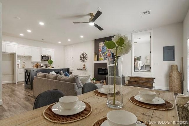 dining area with recessed lighting, visible vents, a glass covered fireplace, ceiling fan, and wood finished floors