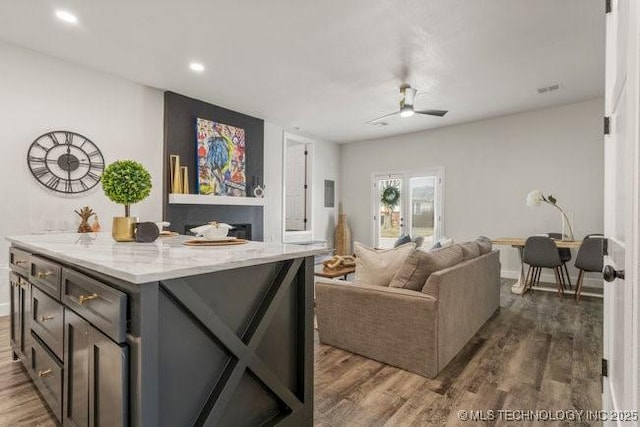 living area with dark wood-type flooring, recessed lighting, a ceiling fan, and baseboards