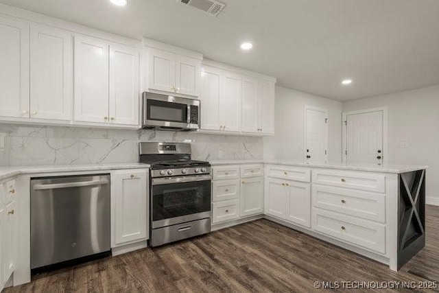 kitchen with visible vents, white cabinets, dark wood-type flooring, a peninsula, and stainless steel appliances