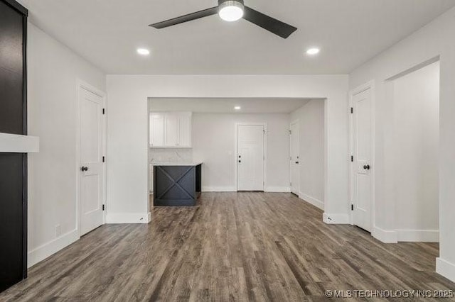 unfurnished living room with baseboards, dark wood-style flooring, and recessed lighting