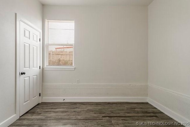 spare room with dark wood-style floors and baseboards