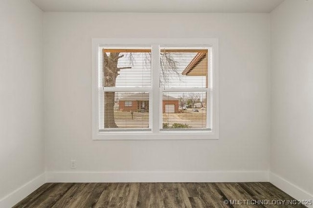 unfurnished room with dark wood finished floors and baseboards