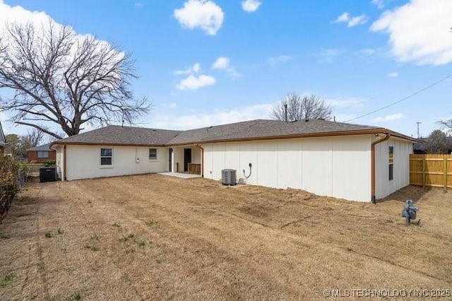 back of property featuring central AC unit and fence