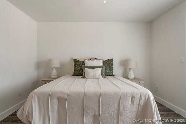 bedroom with baseboards and wood finished floors