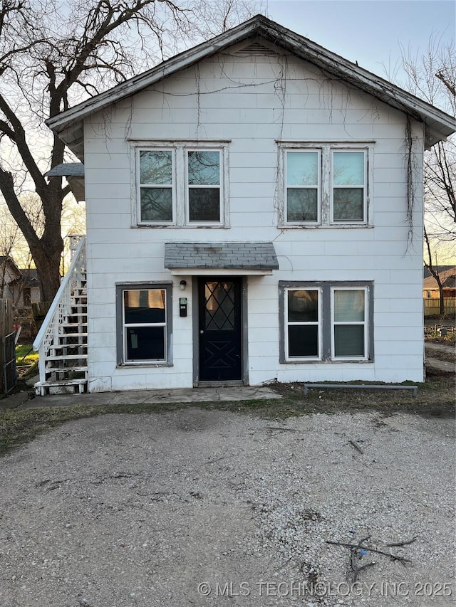 view of front facade featuring driveway and stairs