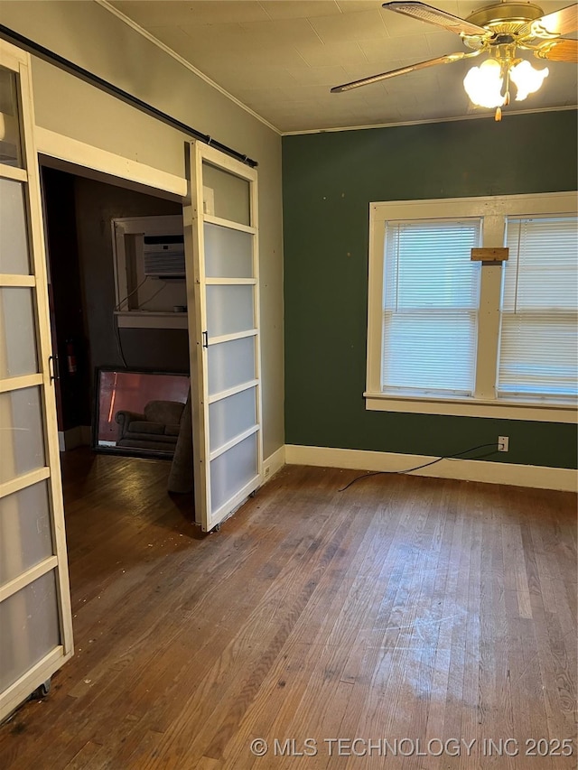 unfurnished room featuring baseboards, ceiling fan, ornamental molding, and hardwood / wood-style floors