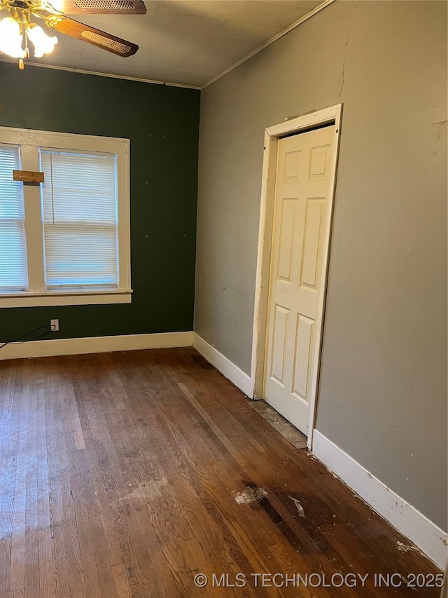 spare room featuring a ceiling fan, ornamental molding, baseboards, and hardwood / wood-style flooring