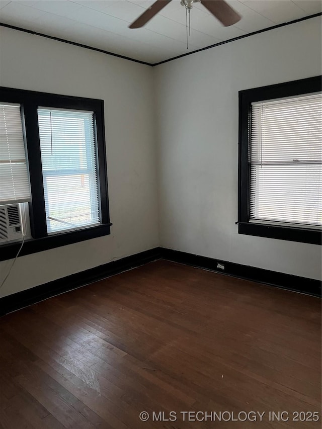 unfurnished room featuring dark wood-style floors, cooling unit, and baseboards