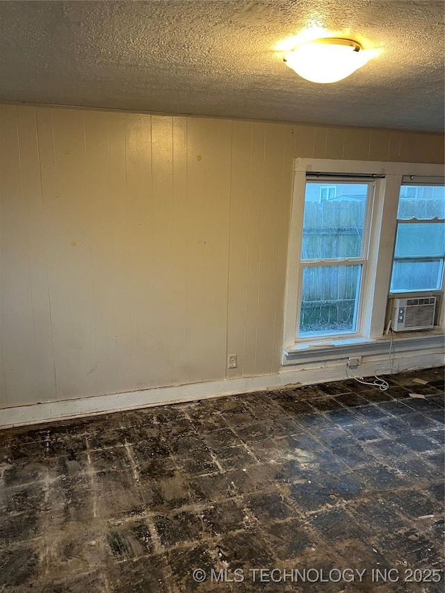 empty room with a textured ceiling and cooling unit