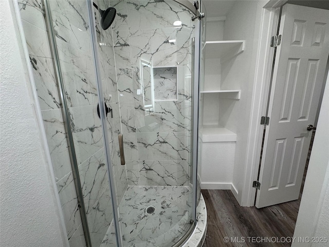 full bath with a textured wall, wood finished floors, and a marble finish shower