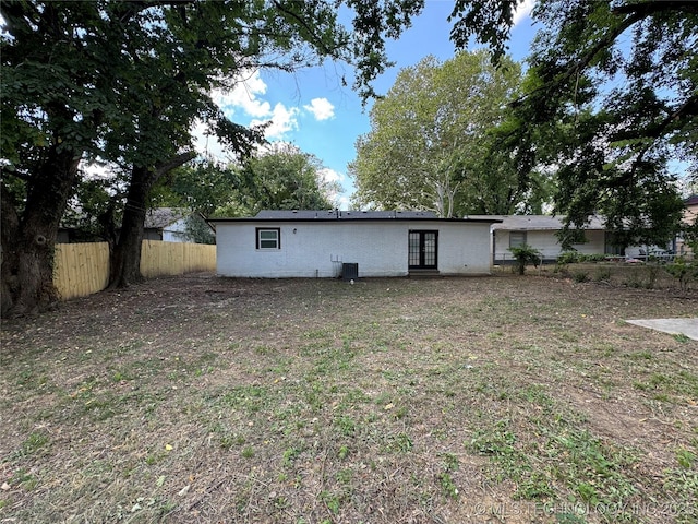 rear view of property featuring french doors and fence