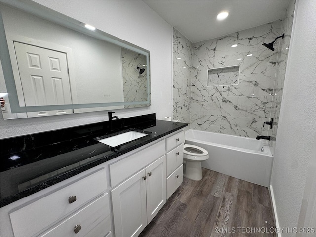 bathroom with toilet, shower / washtub combination, wood finished floors, and vanity