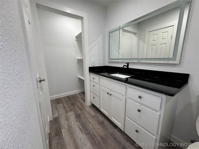 bathroom featuring vanity, baseboards, and wood finished floors