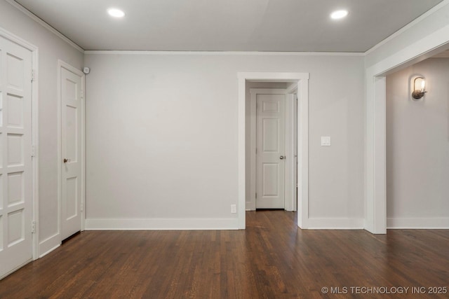 empty room featuring dark wood finished floors, recessed lighting, baseboards, and ornamental molding