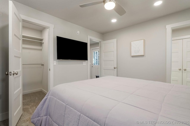 carpeted bedroom featuring a spacious closet, connected bathroom, ceiling fan, recessed lighting, and a closet