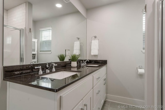 bathroom featuring a sink, baseboards, a shower stall, and tile patterned flooring