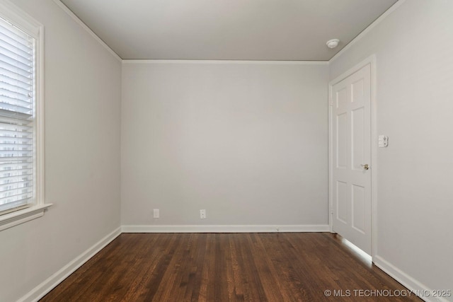 spare room featuring crown molding, dark wood-style floors, and baseboards